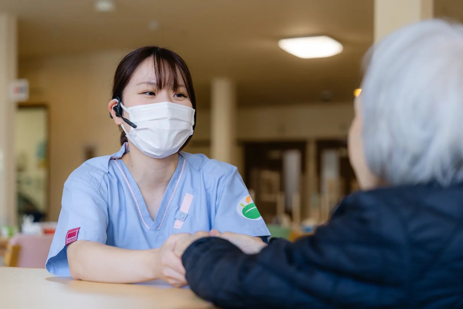 ご入居者さまの手を取り、話を聞くスタッフ